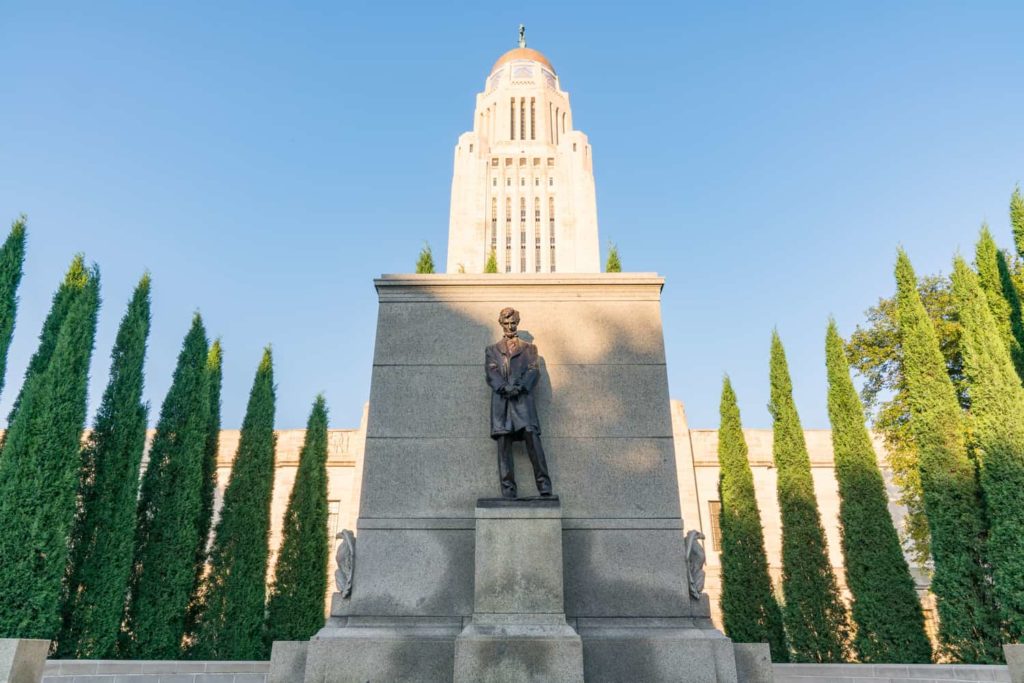 Status of Abraham Lincoln outside the Nebraska Capitol Building in Lincoln against a blue sky